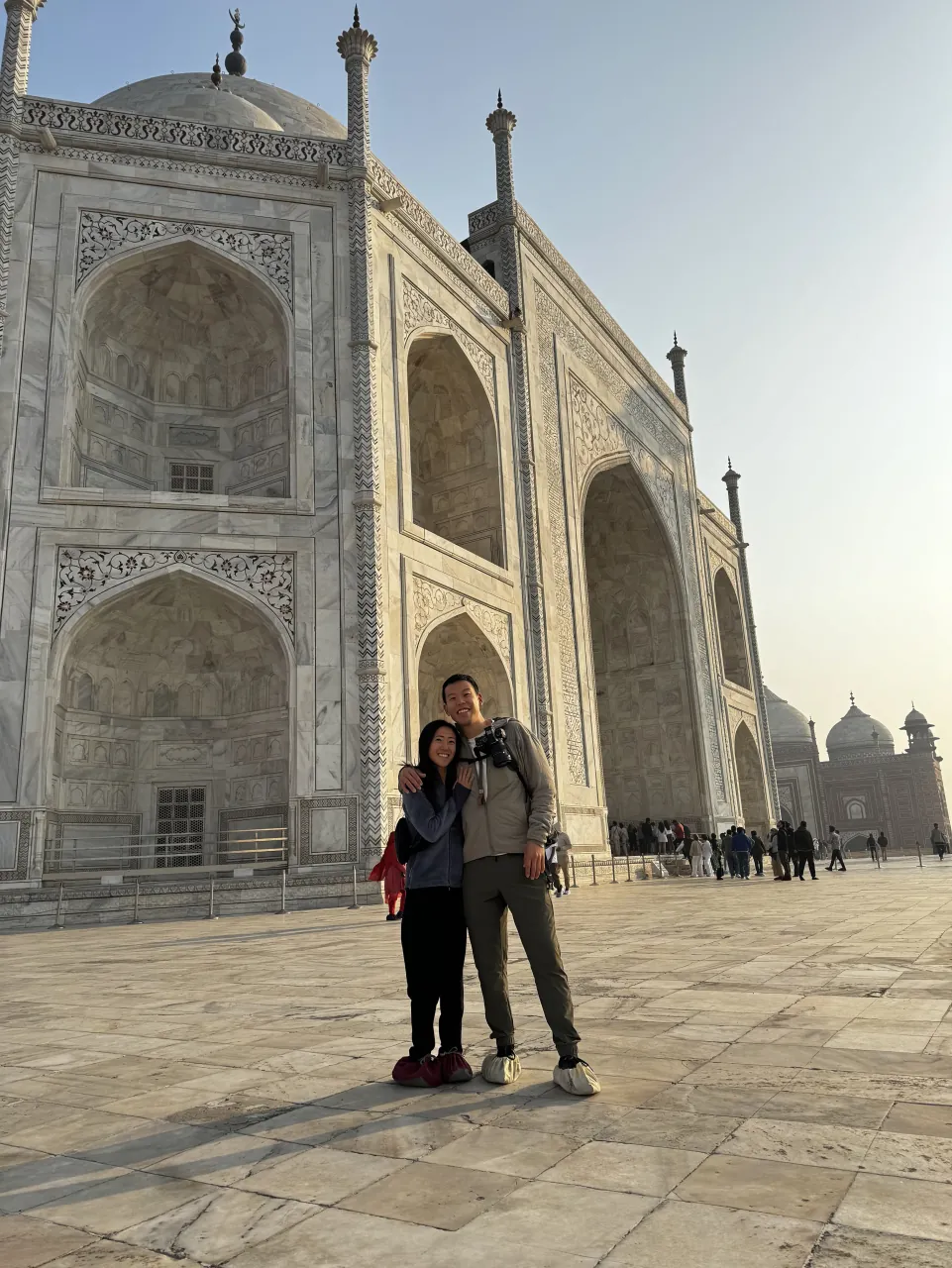 Deyu and Meesh posing at the base of the white marble Taj Mahal in Agra, India.